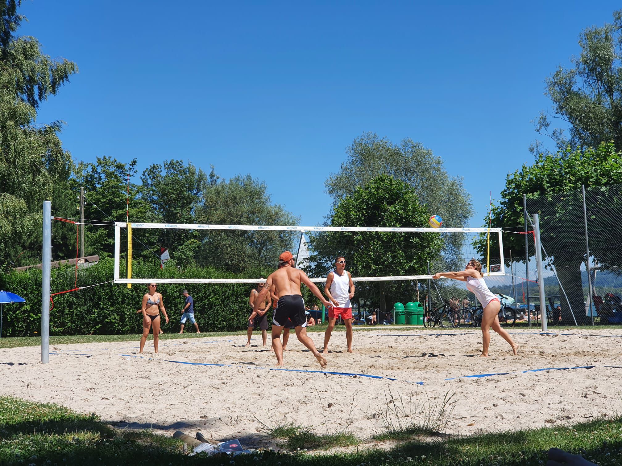 WhatsApp Image 2025-06-09 à 17.10.50_5f8844fc Three athletes competing fiercely in an indoor volleyball match, showcasing a perfect spike block.